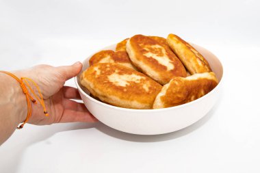 El ele tutuşup arka planda izole edilmiş ev yapımı kızarmış hamur işleri.