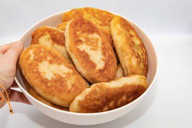 El ele tutuşup arka planda izole edilmiş ev yapımı kızarmış hamur işleri.