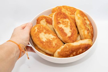 El ele tutuşup arka planda izole edilmiş ev yapımı kızarmış hamur işleri.