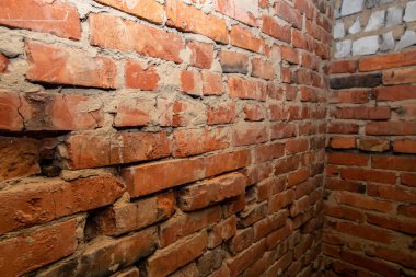 İnşaat arka planında sert duvarları olan eski tuğla iç köşe.