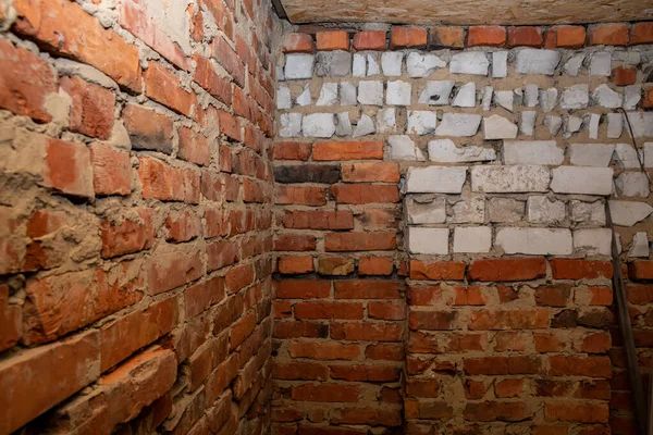 İnşaat arka planında sert duvarları olan eski tuğla iç köşe.