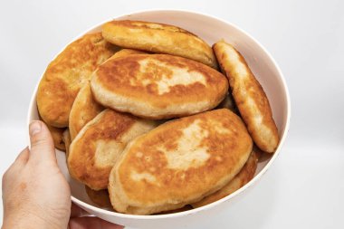 Beyaz arka planda elle tutulan ev yapımı kızarmış turtalar.