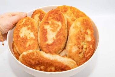 Beyaz arka planda elle tutulan ev yapımı kızarmış turtalar.