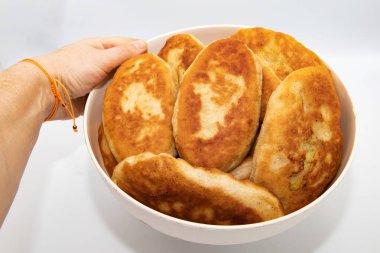 Beyaz arka planda elle tutulan ev yapımı kızarmış turtalar.