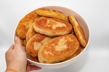 Beyaz arka planda elle tutulan ev yapımı kızarmış turtalar.