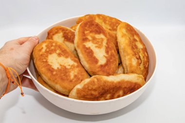 Beyaz arka planda elle tutulan ev yapımı kızarmış turtalar.