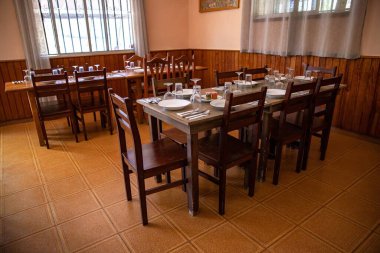 Misafirler için hazırlanmış ahşap masaları olan boş geleneksel restoran yemek odası.