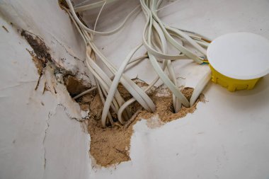 Tadilat sırasında hasar gören duvarın içinde elektrik kabloları ve bağlantı kutusu ortaya çıktı.