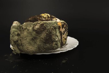 Gelişmiş mantar çürümesini gösteren ağır küflü ekmek somunu siyah arka planda izole edilmiş.