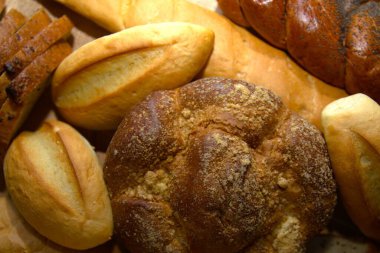 Türlü taze ekmek somunları ve altın kabuklu çörekler.