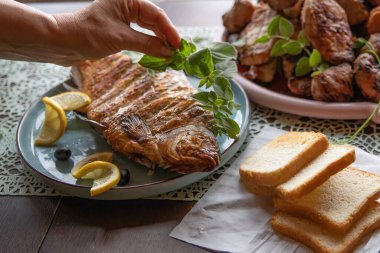 Geleneksel ev yemeği olarak servis edilen limonlu ekmekle ızgara balık.
