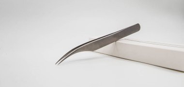 Kirpik uzantısı için profesyonel cımbızlar beyaz arka plan stüdyosunda izole edilmiş.