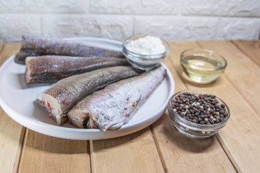 Tahtadaki un ve baharatlarla hazırlanmış balık parçaları.