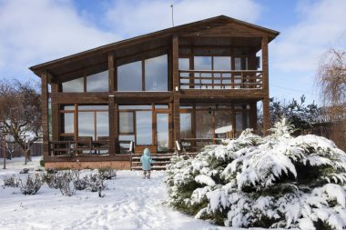 Karlı bahçesi olan modern ahşap kır evi kış tatili için kiralanabilir.