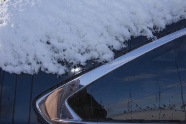 Soğuk kış sabahı bakımı sırasında araba camı eriyen karla kaplıydı.