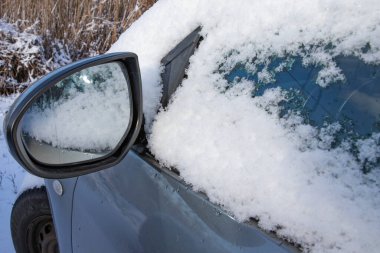 Karla kaplı araba penceresi, gece boyunca kar yağdıktan sonra kalın kış ayazıyla kaplı.