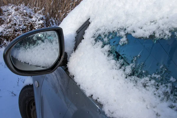 Karla kaplı araba penceresi, gece boyunca kar yağdıktan sonra kalın kış ayazıyla kaplı.