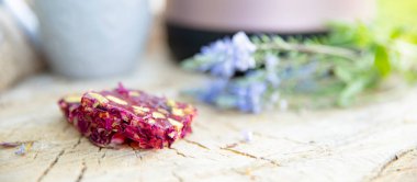 Çilekli fındık enerji barı, kabın yanındaki ahşap yüzeyde bitkiler.