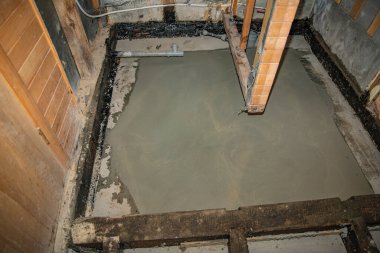 Banyo tadilatı sırasında temiz beton döşeme görünür tesisat ve ahşap yapı ile döşenmiş.