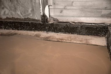 Banyo tadilatı sırasında temiz beton döşeme görünür tesisat ve ahşap yapı ile döşenmiş.