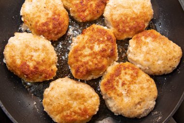 Çiğ ekmekli et pirzolası tavada kızartılıyor.