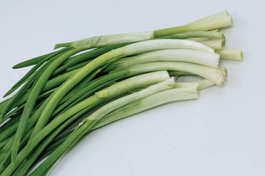 Taze yeşil soğan sürüsü yemek kullanımı için beyaz arka plan stüdyosuna izole edilmiş.
