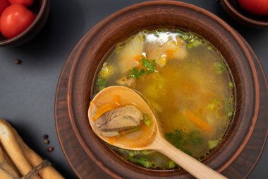 Kil kâse ahşap kaşık manzaralı sebzeli ördek çorbası