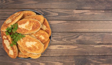 Koyu tabak masasında maydanozla süslenmiş hamur köfteleri.