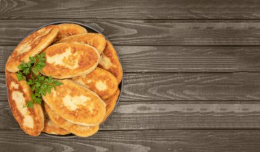 Koyu tabak masasında maydanozla süslenmiş hamur köfteleri.