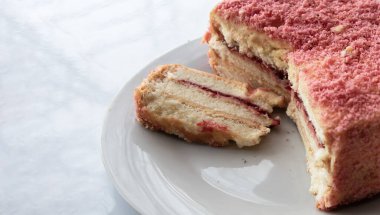 Beyaz tabak manzaralı kremalı ve çilekli kek.