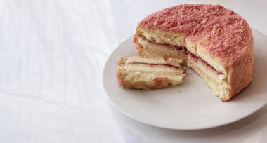 Beyaz tabak manzaralı kremalı ve çilekli kek.