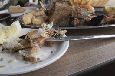 Akşam yemeğinden sonra kızarmış balık, deniz mahsulü ve limon tabağı.