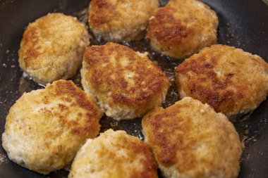 Ev yemeği sırasında tavada pişen çiğ ekmek köfteleri.