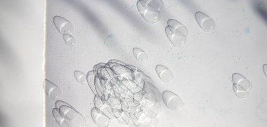 Su beyaz desenli kağıt yüzeyine ışık gölge desenli damlalar.