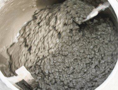 Beton karışımı inşaat sırasında endüstriyel karıştırıcının içinde mekanik olarak karıştırılıyor.