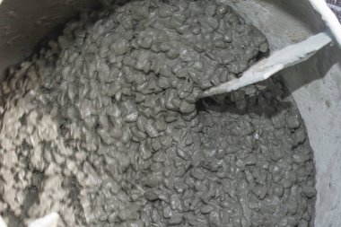 Beton karışımı inşaat sırasında endüstriyel karıştırıcının içinde mekanik olarak karıştırılıyor.