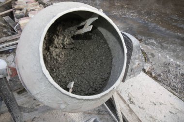 Beton karışımı inşaat sırasında endüstriyel karıştırıcının içinde mekanik olarak karıştırılıyor.