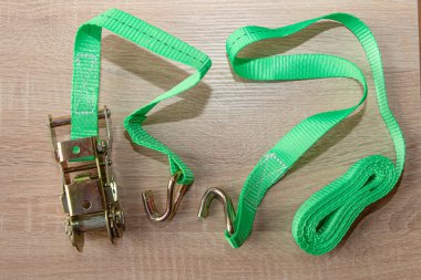 Ahşap yüzeye metal kancalarla bağlanmış yeşil cırcır bağı.