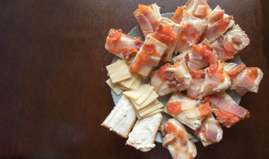 Ekmek yağlı peynirli sandviçler ve tabağın üstünde füme balık.