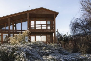 Kışın bahçesinde geniş pencereleri olan modern ahşap ev.