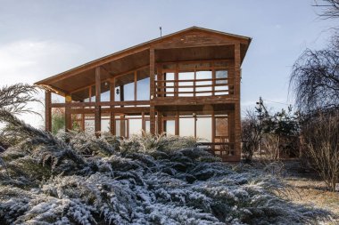Kışın bahçesinde geniş pencereleri olan modern ahşap ev.
