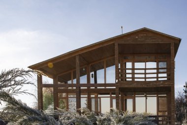 Kışın bahçesinde geniş pencereleri olan modern ahşap ev.