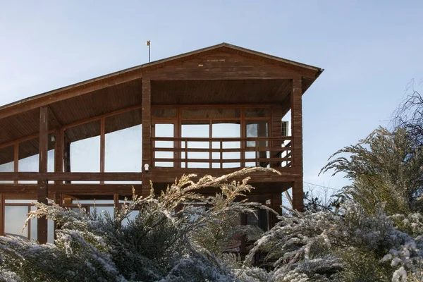 Kışın bahçesinde geniş pencereleri olan modern ahşap ev.