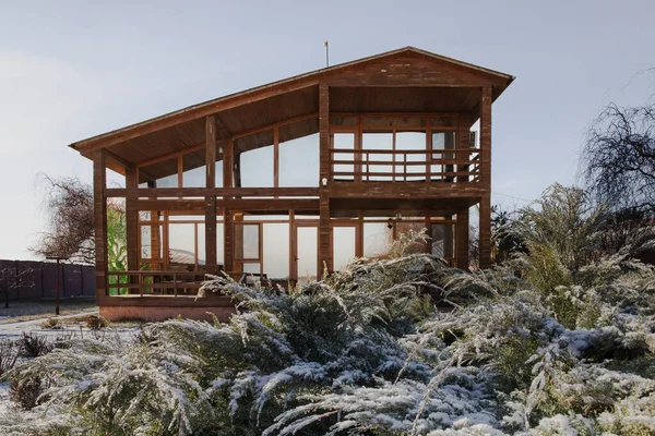 Kışın bahçesinde geniş pencereleri olan modern ahşap ev.