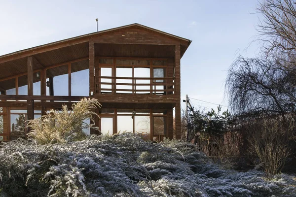 Kışın bahçesinde geniş pencereleri olan modern ahşap ev.