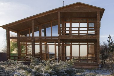 Kışın bahçesinde geniş pencereleri olan modern ahşap ev.