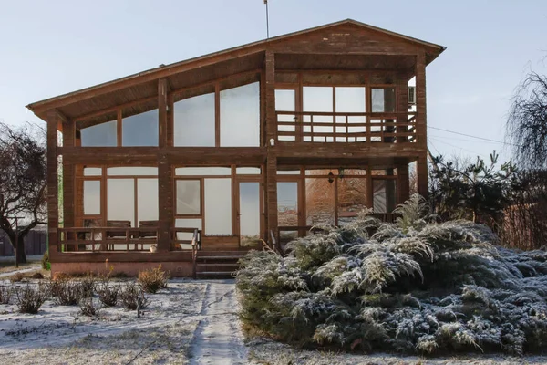 Kışın bahçesinde geniş pencereleri olan modern ahşap ev.
