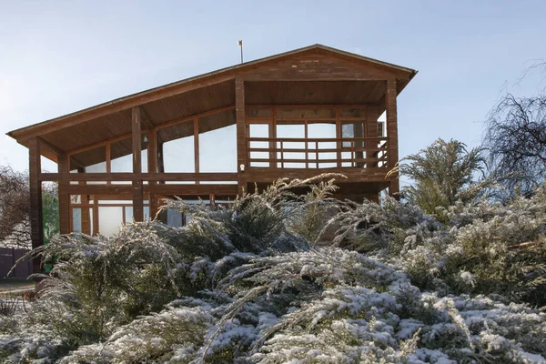 Kışın bahçesinde geniş pencereleri olan modern ahşap ev.