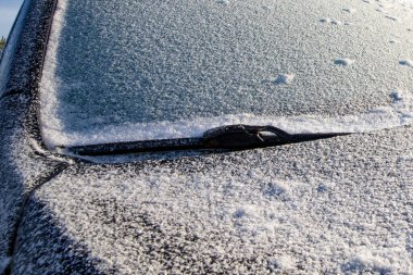 Soğuk kış sabahı arabanın ön camı ve kaputu kar ve buzla kaplıydı.