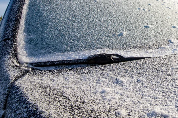 Soğuk kış sabahı arabanın ön camı ve kaputu kar ve buzla kaplıydı.
